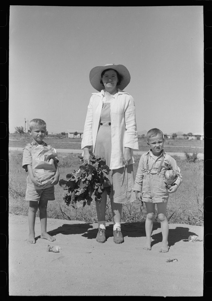 Supervisor of the Work Projects Administration nursery school and boys with vegetables from the community garden at the Casa…