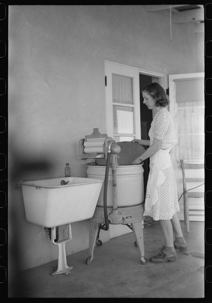 Woman living at the Casa Grande Valley Farms, Pinal County, Arizona, removing the cover from her electric washing machine by…