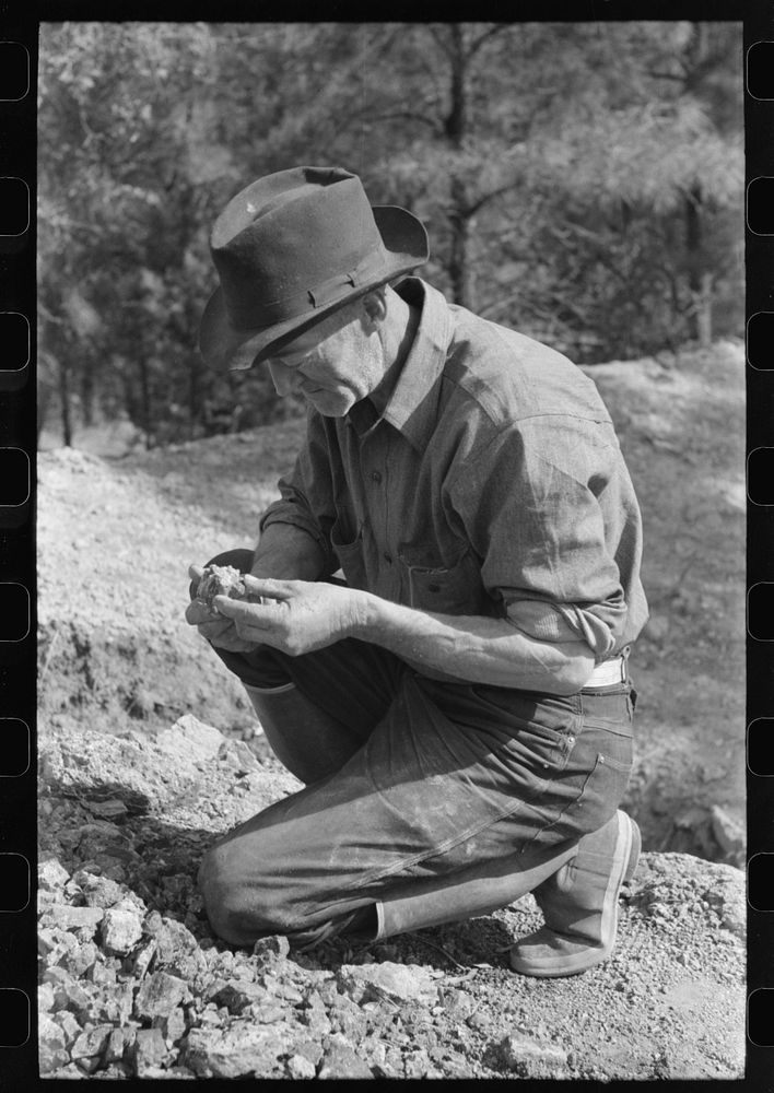 Prospector examining a piece of rock, Pinos Altos, New Mexico by Russell Lee