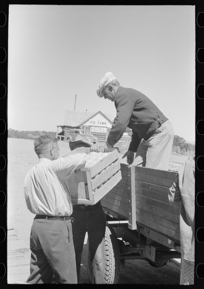 Mr. Keele taking crate of grapefruit from truck. General store, Pie Town, New Mexico by Russell Lee