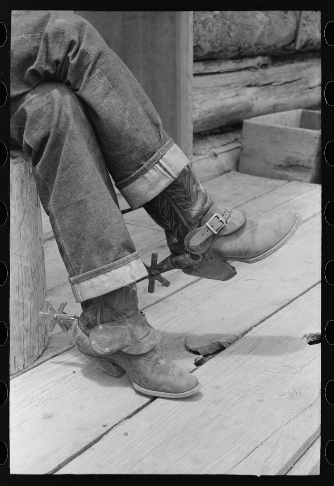 [Untitled photo, possibly related to: Detail of farmer's blue jeans, boots and spurs. This man was once a cowboy and still…