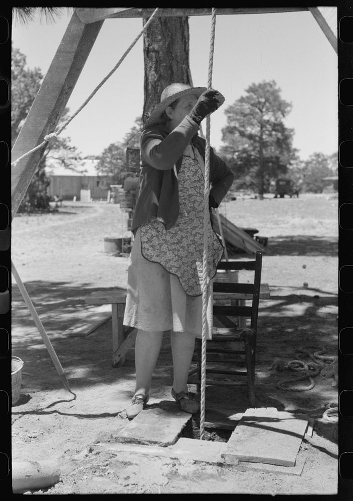 [Untitled photo, possibly related to: Woman guiding the drilling tool for water well drilling. Pie Town, New Mexico] by…