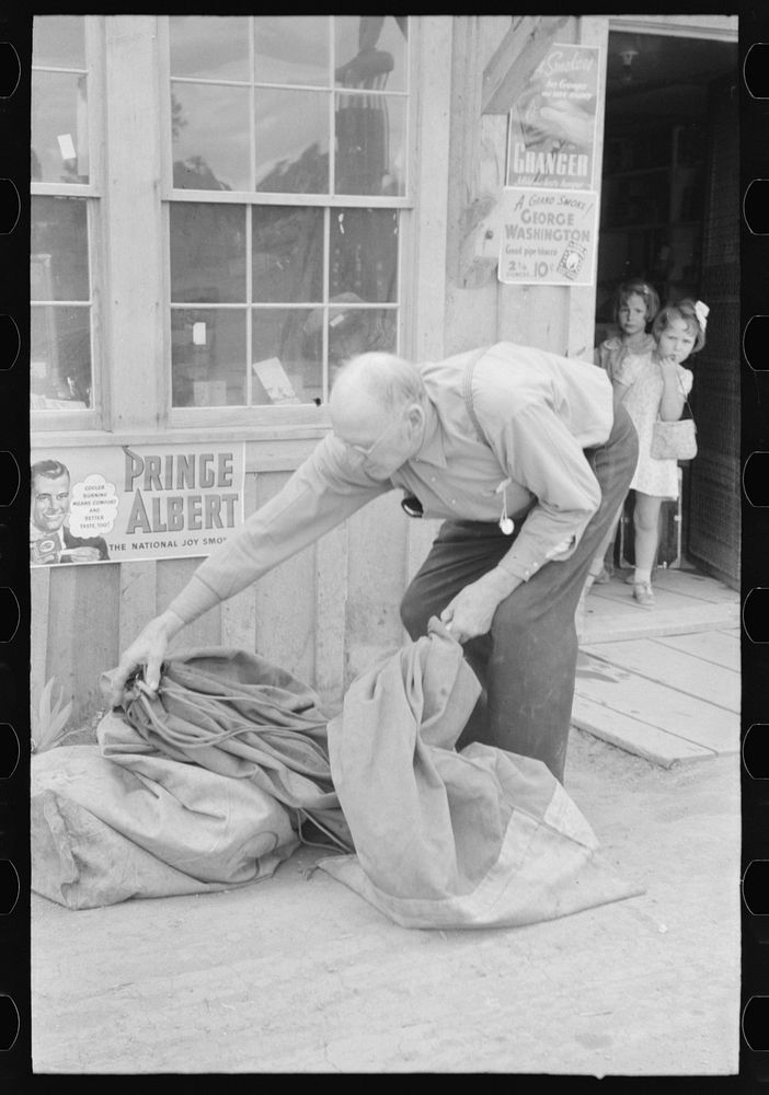 Postmaster bringing in the mail sacks. Pie Town, New Mexico by Russell Lee