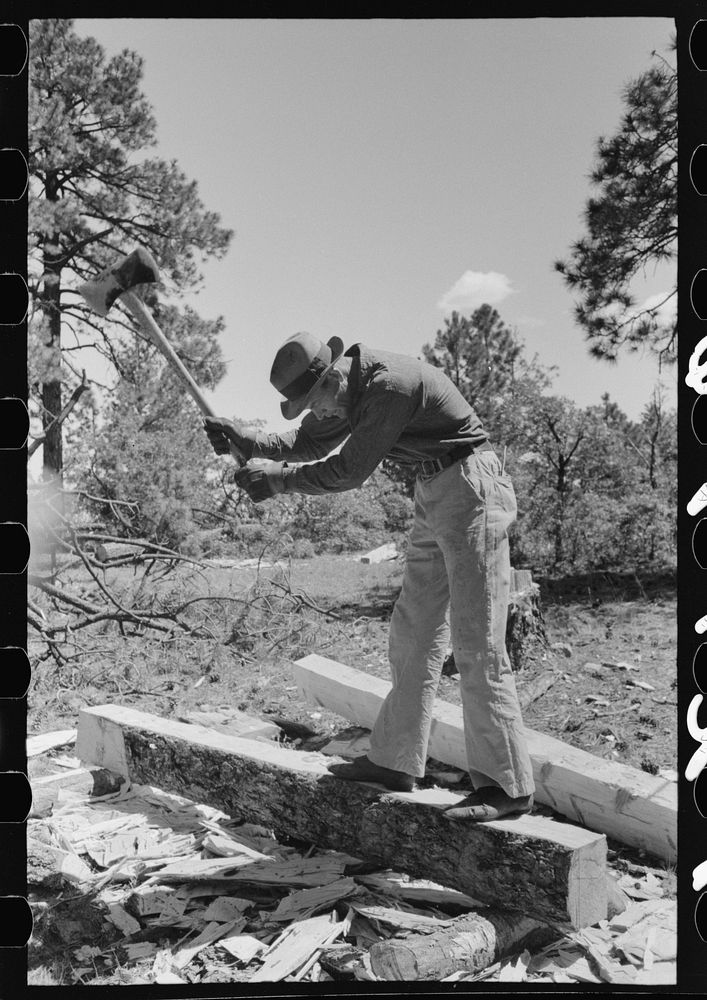 Chipping off the slab before log is finished with broadaxe into a tie. Pie Town, New Mexico by Russell Lee