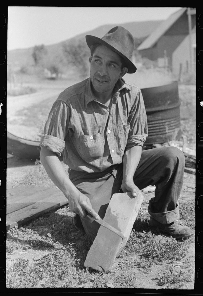 Spanish-American farmer sharpening his knife. Chamisal, New Mexico by Russell Lee