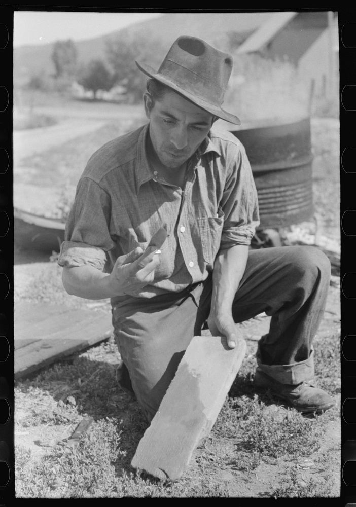 Spanish-American farmer whetting his knife. Chamisal, New Mexico by Russell Lee