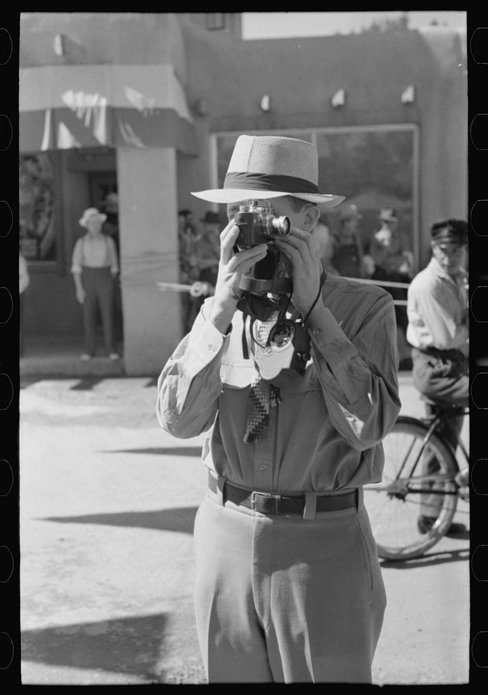 Tourist using candid camera, Taos, New Mexico by Russell Lee