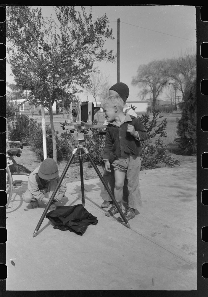 Children at the FSA (Farm Security Administration) Camelback Farms inspect the photographer's camera, Phoenix, Arizona by…