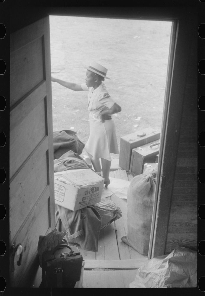 Florida migrant with luggage waiting to leave Belcross, North Carolina for another job at Onley, Virginia. Sourced from the…