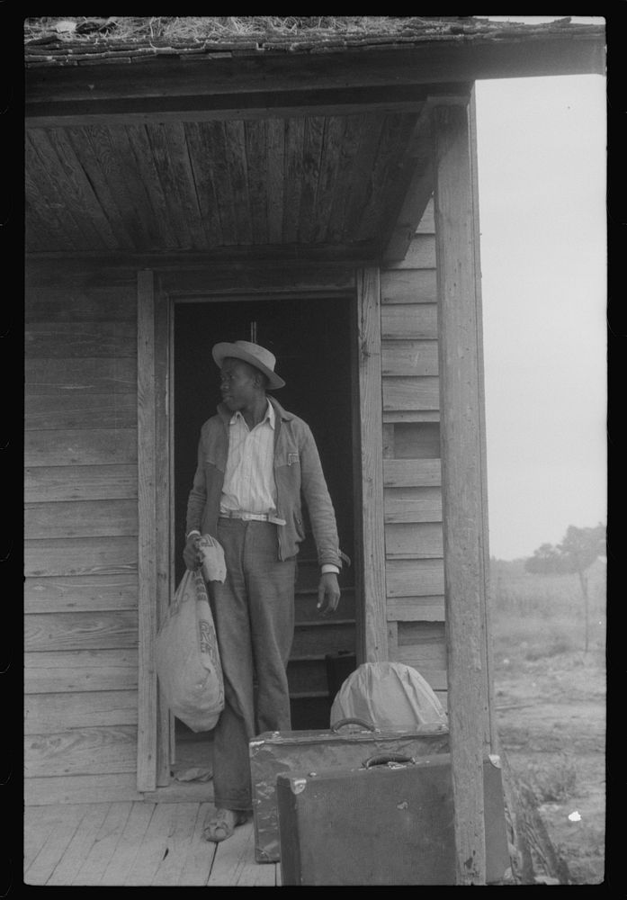 [Untitled photo, possibly related to: Migrant packing his bag for a trip from Belcross, North Carolina to another job at…