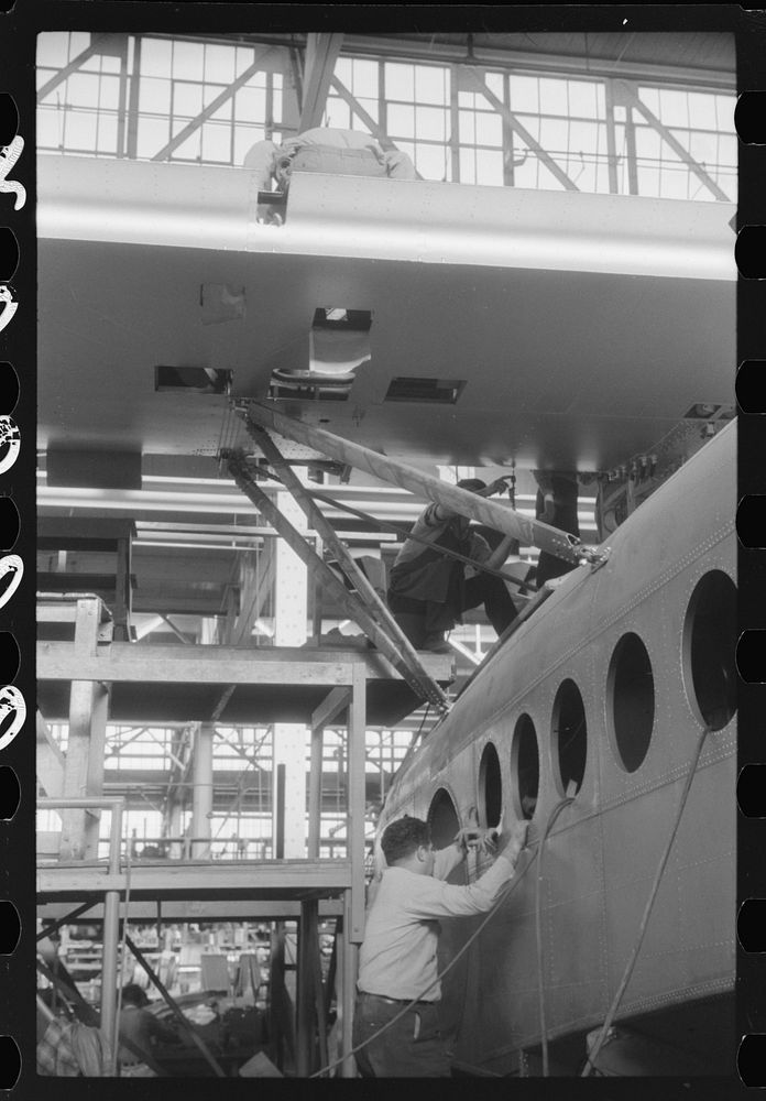 Working on a giant seaplane at the Vought-Sikorsky Aircraft Corporation, Stratford, Connecticut. Sourced from the Library of…