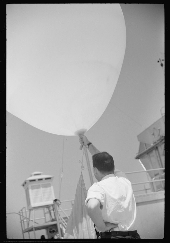 [Untitled photo, possibly related to: Preparing to send up the weather balloon at the weather bureau at the municipal…