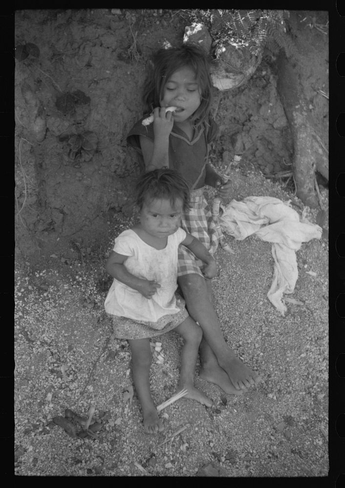 Farm laborer's children eating sugar cane in the hills near Yauco, Puerto Rico. Sourced from the Library of Congress.