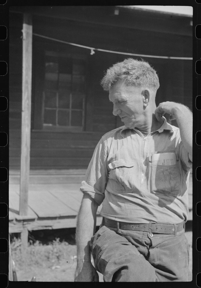 [Untitled photo, possibly related to: Former coal miner sitting on his front porch. He is the town philosopher. He repairs…