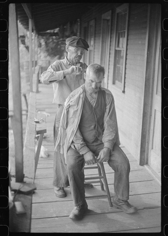 Miners often give haircuts on front porch. The "Patch," Chaplin, West Virginia. Sourced from the Library of Congress.