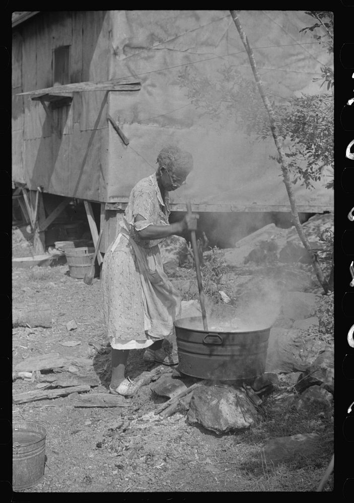 Woman washing clothes outside of shacks along the river, on the highway between Charleston and Gauley Bridge, West Virginia…