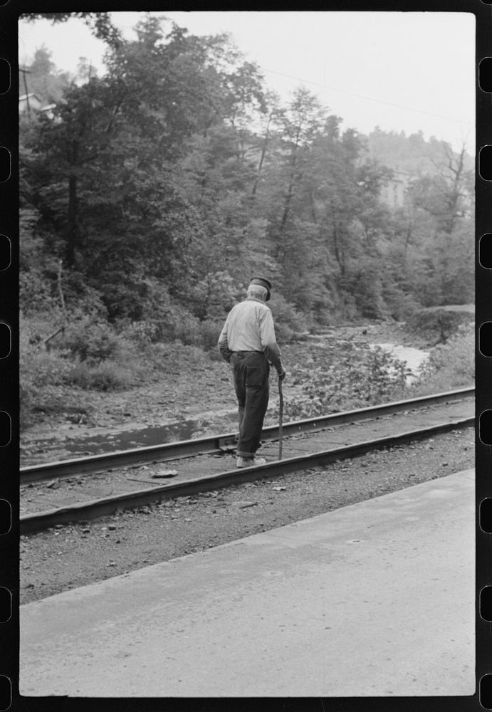 [Untitled photo, possibly related to: Woman (probably Hungarian) coming home along railroad tracks in coal mining town…