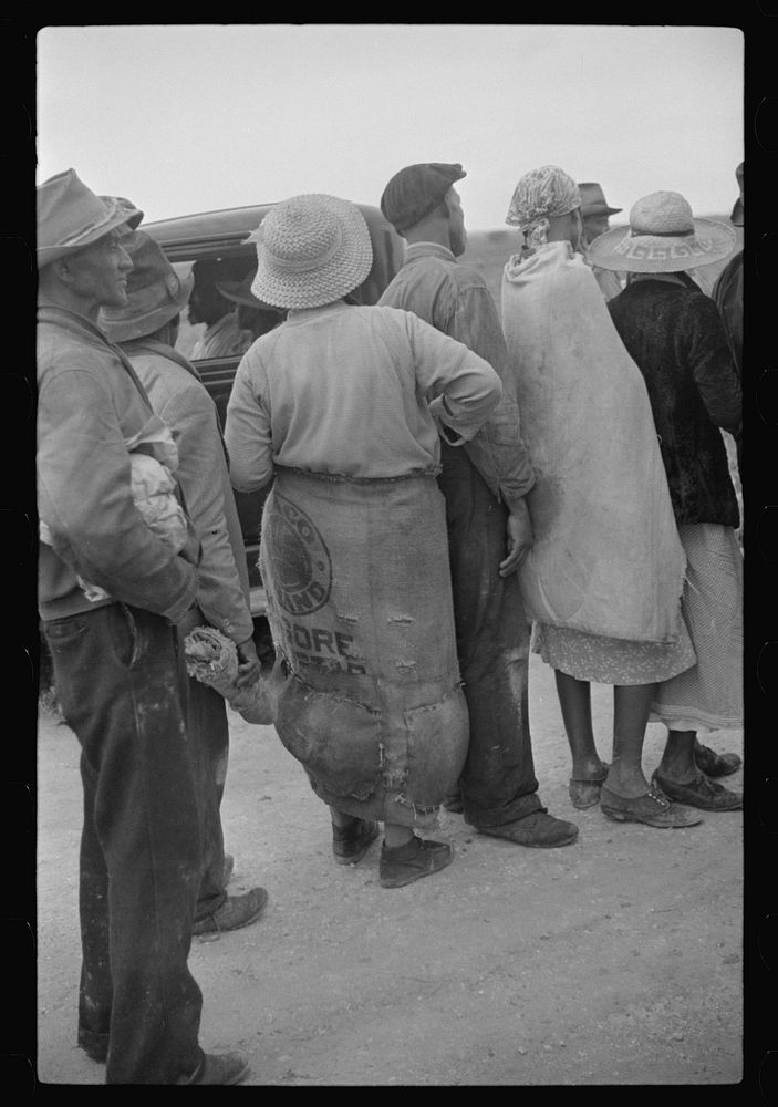 Homestead (vicinity), Florida. Migrant vegetable pickers waiting after work for their pay. Sourced from the Library of…