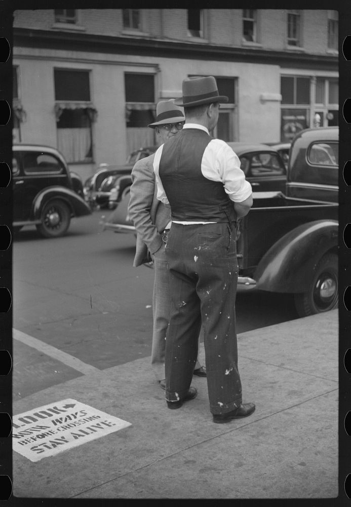 Cotton brokers talking outside cotton exchange building, Front Street, Memphis, Tennessee. Sourced from the Library of…