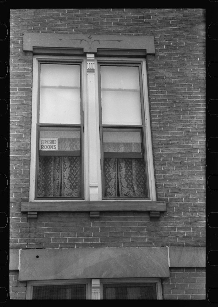 [Untitled photo, possibly related to: Signs in window, evidence of boom town and crowded housing conditions. Hartford…