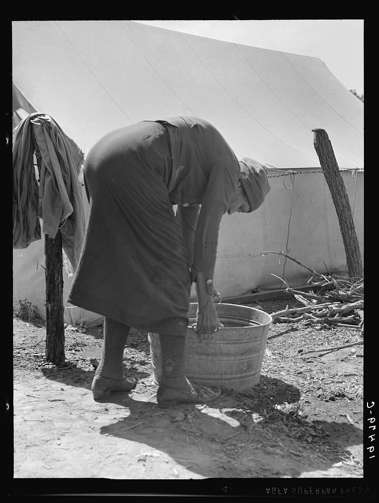 A grandmother washing clothes in a migrant camp. Stanislaus County, California. Sourced from the Library of Congress.