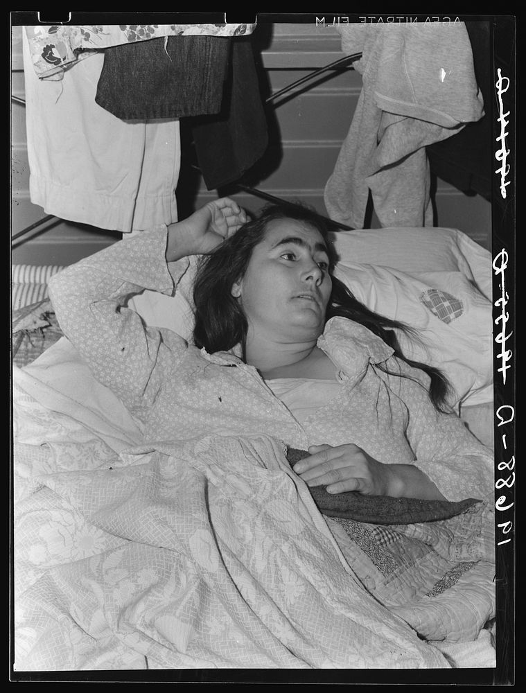 Tulare County, California. Sick woman in Farm Security Administration (FSA) camp for migratory agricultural workers. Sourced…