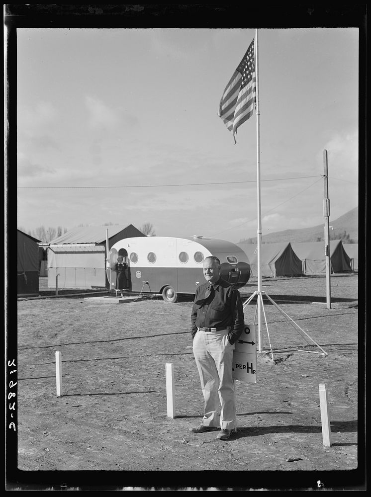 The camp manager at camp entrance. Merrill, Klamath County, Oregon. FSA (Farm Security Administration). Clinic trailer shown…