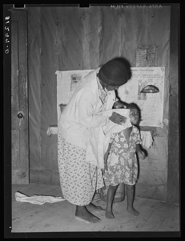 Wife of sharecropper washing daughter's face. Family will participate in tenant purchase program. Near Caruthersville…