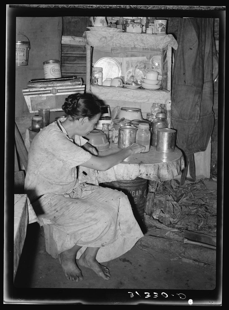 Resident of Tin Town, Caruthersville, Missouri, sitting at kitchen table by Russell Lee