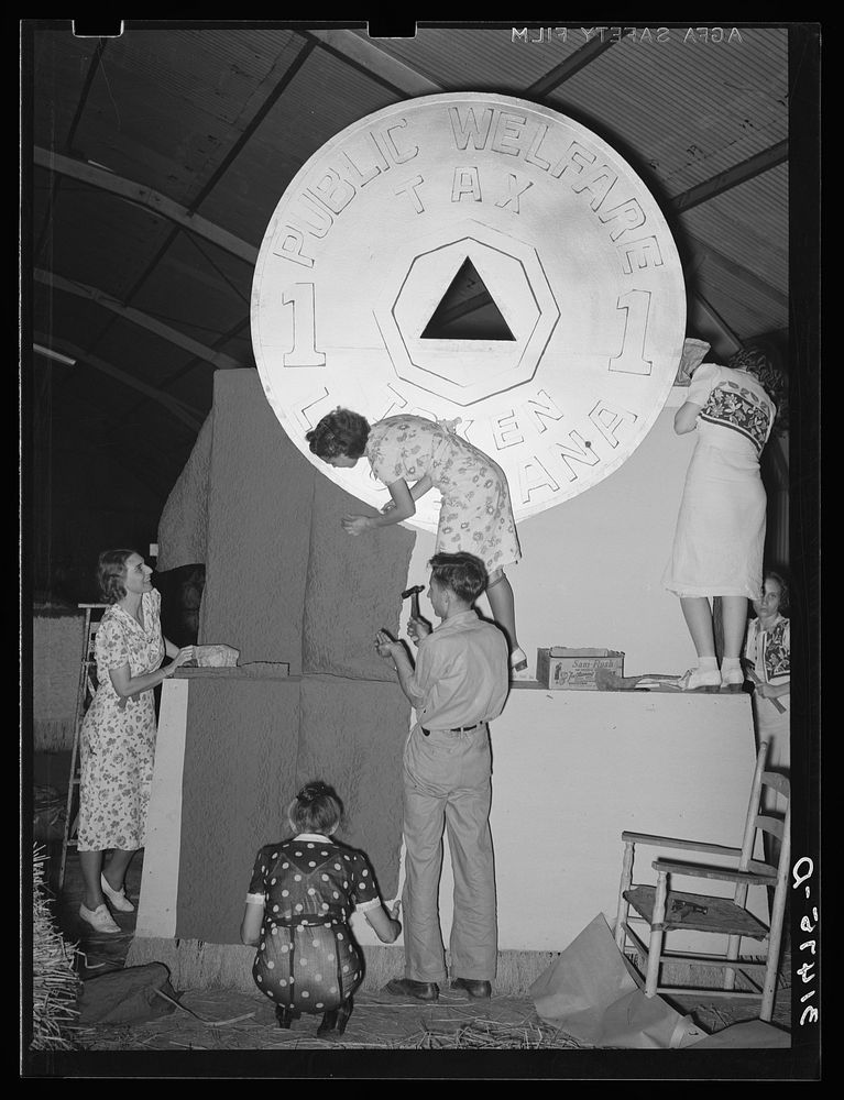 Decorating float of state of Louisiana with the token symbol of the state welfare tax prominently displayed. National Rice…