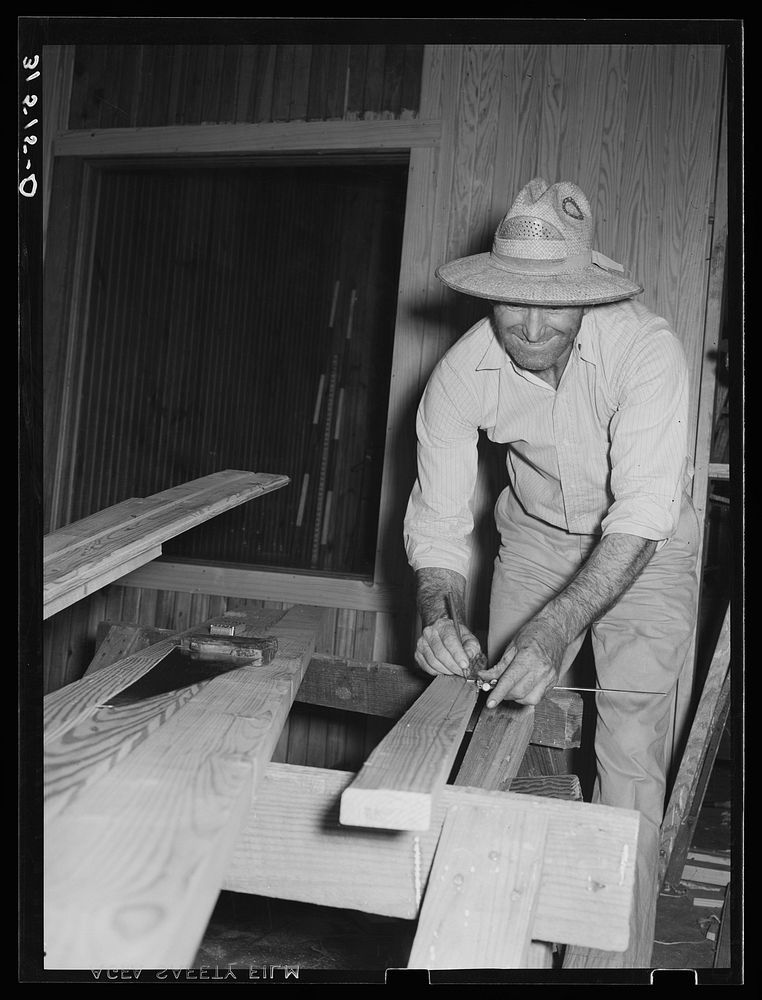 [Untitled photo, possibly related to: Member of Lake Dick cooperative association installing window of partition in general…