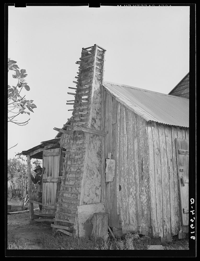 Part of home of aged couple, with mud and moss chimney held together by sticks. Crowley, Louisiana by Russell Lee