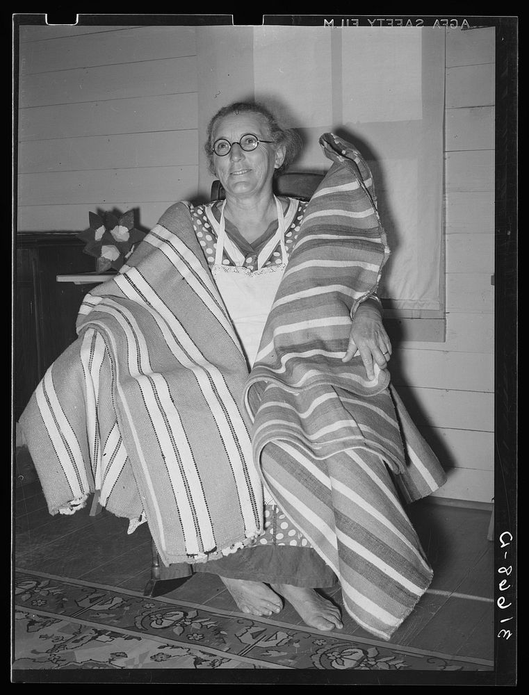 Cajun woman with homespun blankets. Note the bare feet. Near Crowley, Louisiana by Russell Lee