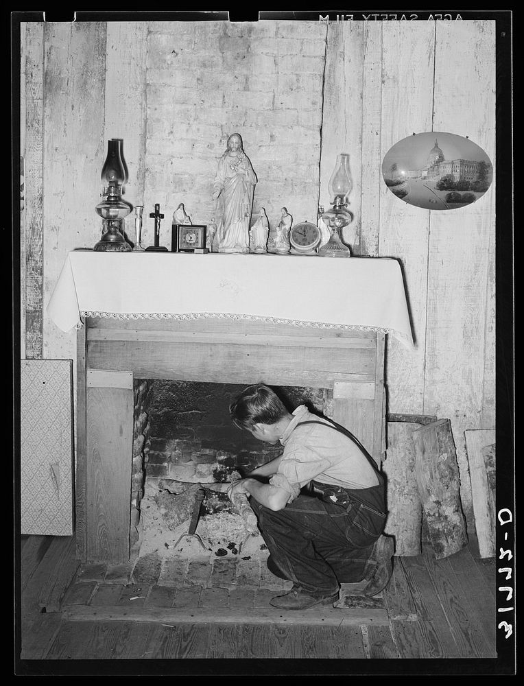 Son of M. LaBlanc building a fire in present farm home. Morganza, Louisiana. The LaBlancs are tenant purchase clients by…