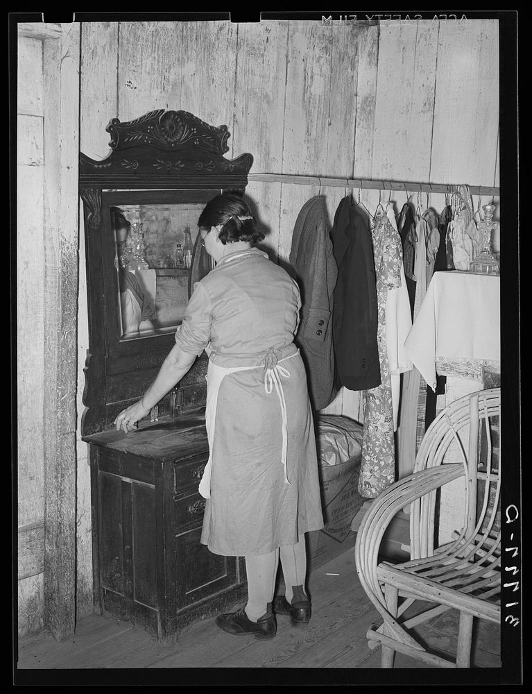 Mrs. M. LaBlanc arranging articles on dresser. Note improvised closet space in this home. La Blancs will be tenant purchase…