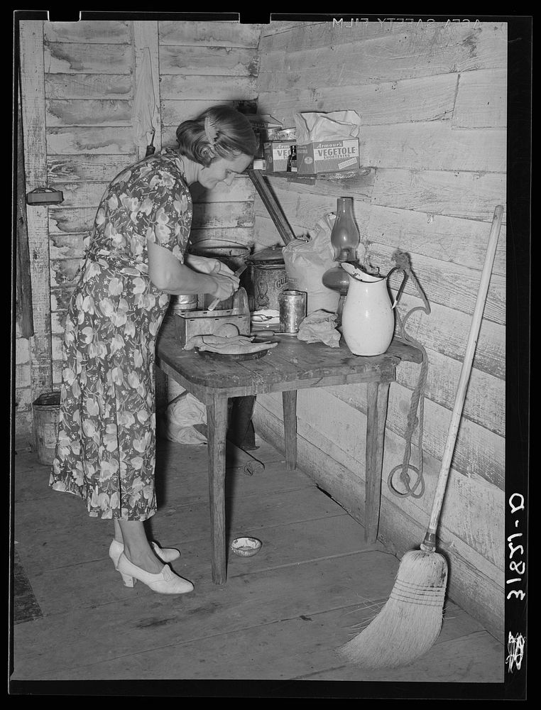 Mrs. Adams, wife of farmer near Morganza, Louisiana, preparing sweet potatoes for dinner. Family will shortly be helped by…