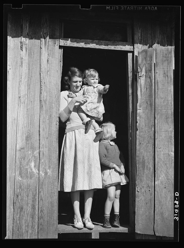 Mrs. Ed Bagget with two children in doorway of sharecropper cabin near Laurel, Mississippi by Russell Lee