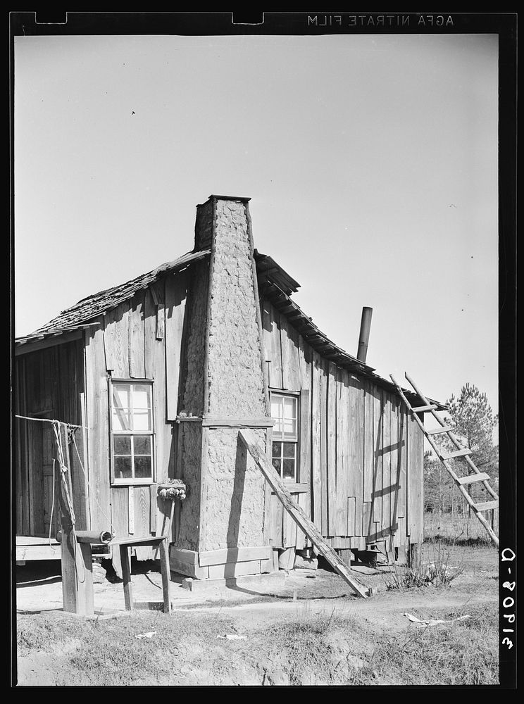 [Untitled photo, possibly related to:  cabin, showing grass and mud chimney and broom made of corn husks for sweeping yard.…