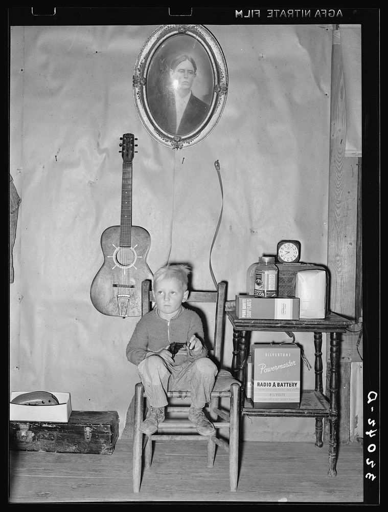 Son of tenant farmer in corner of living room. Pace, Mississippi. Background photo, Sunflower Plantation by Russell Lee