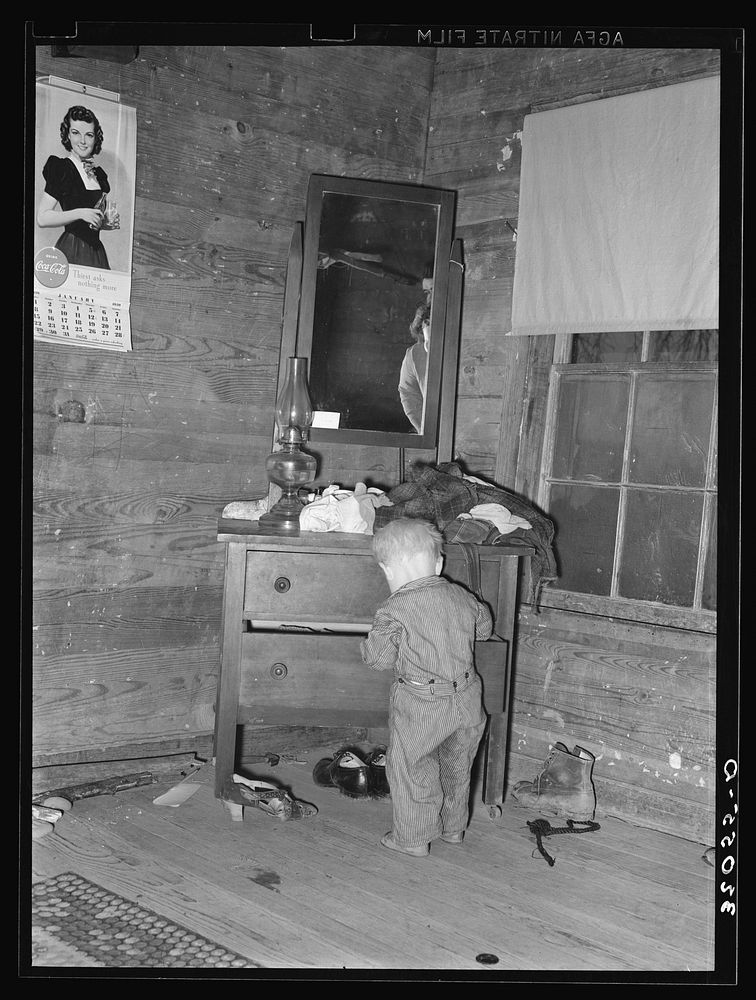 Pace (vicinity), Mississippi, in the Delta area. The corner of a tenant farm living room and bedroom. This family was moved…