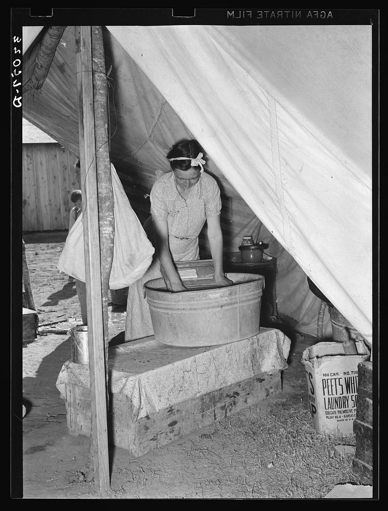 Migrant white mother washing clothes in front of tent home. Weslaco, Texas. See general caption by Russell Lee