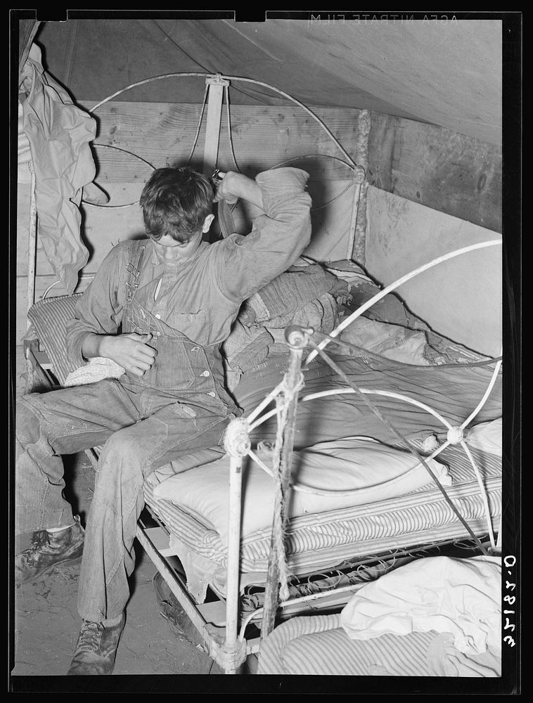 Son of white migrant worker putting on overalls in tent near Harlingen, Texas. See 32108-D by Russell Lee