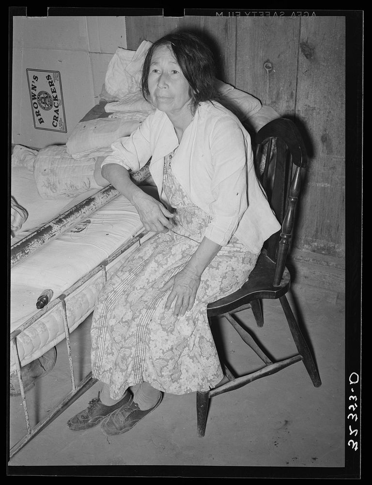 Mexican woman in bedroom. Notice the dirt floor. Crystal City, Texas by Russell Lee