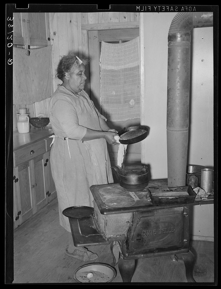 FSA (Farm Security Administration) client making bread in farm home. Sabine Farms, Marshall, Texas by Russell Lee