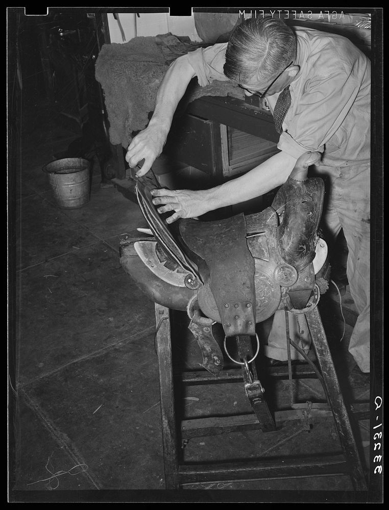 Workman repairing saddle. Alpine, Texas, saddle shop by Russell Lee