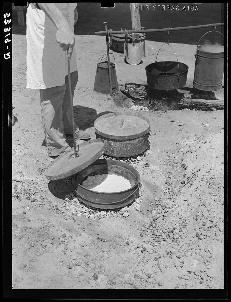 Cook of SMS Ranch making bread in Dutch oven. Near Spur, Texas by Russell Lee