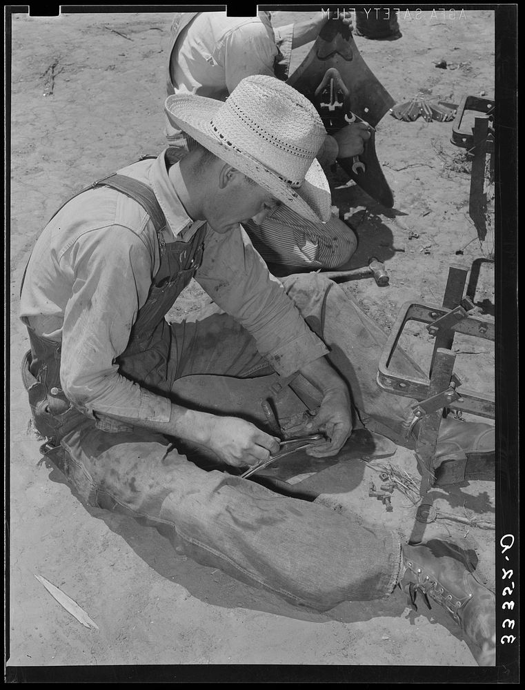 [Untitled photo, possibly related to: Day laborer adjusting plow points on tractor-drawn planter, farm near Ralls, Texas] by…