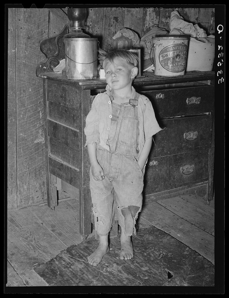 Child of white tenant farmer in kitchen of his home. McIntosh County, Oklahoma. Notice the pail of lard by Russell Lee