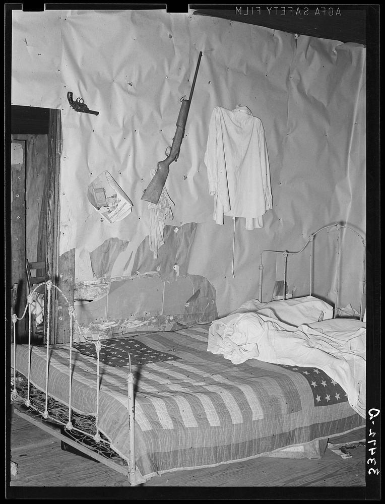 Bedroom of tenant farmer living near Warner, Oklahoma. Notice American flag quilt by Russell Lee