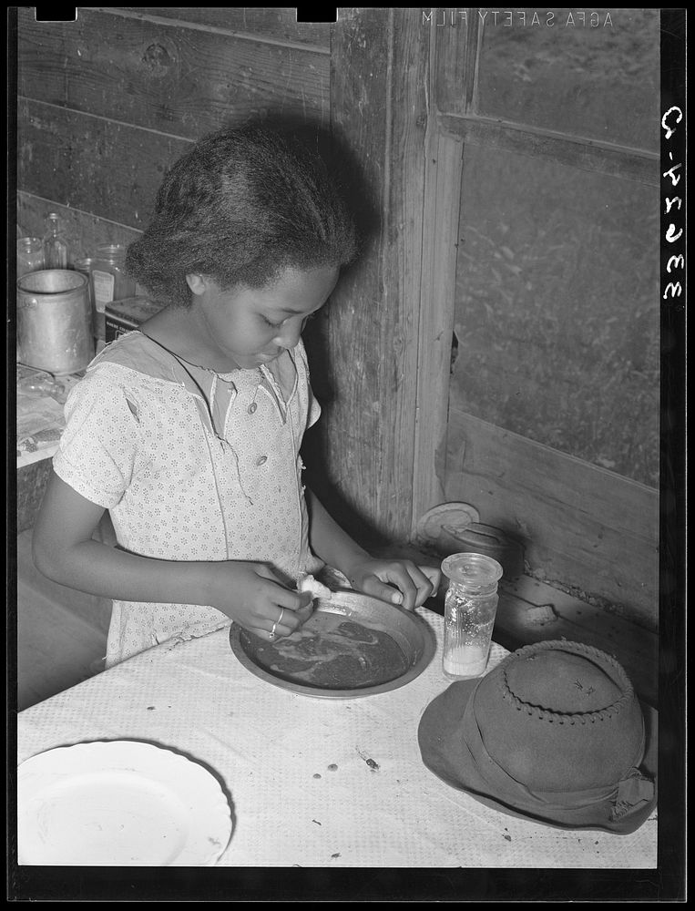 Daughter of  tenant farmer eating bread and flour gravy for dinner. Wagoner County, Oklahoma by Russell Lee